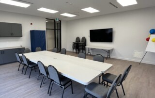 A table and chairs with a television in a room